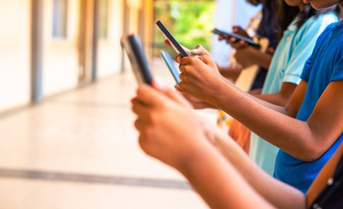 Close up shot, group of children hands busy using smartphone 